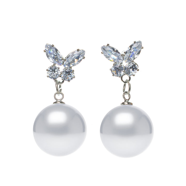 Pearl earrings hanging from a glittering butterfly