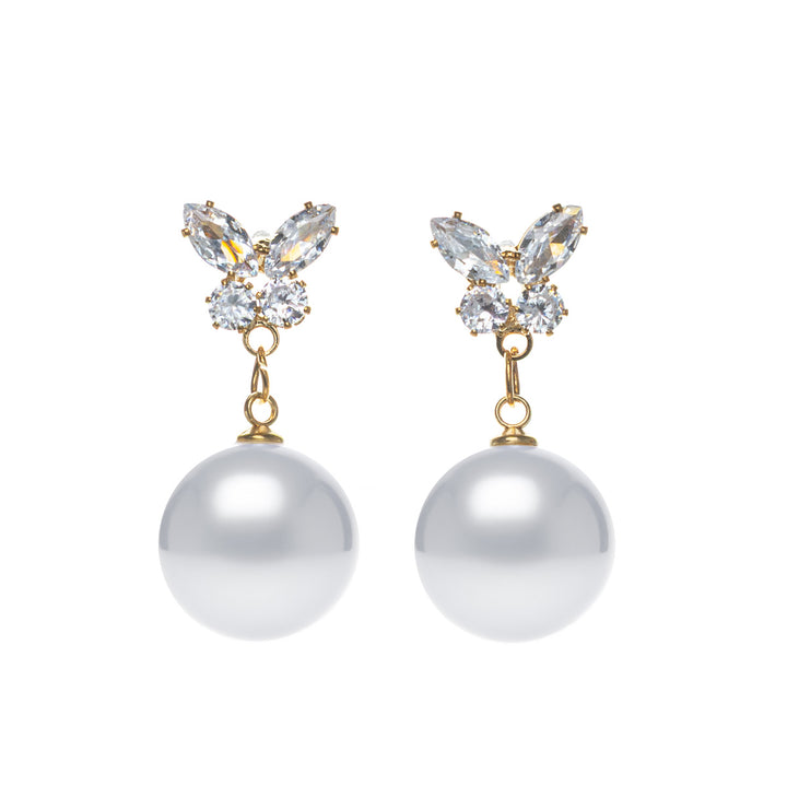 Pearl earrings hanging from a glittering butterfly