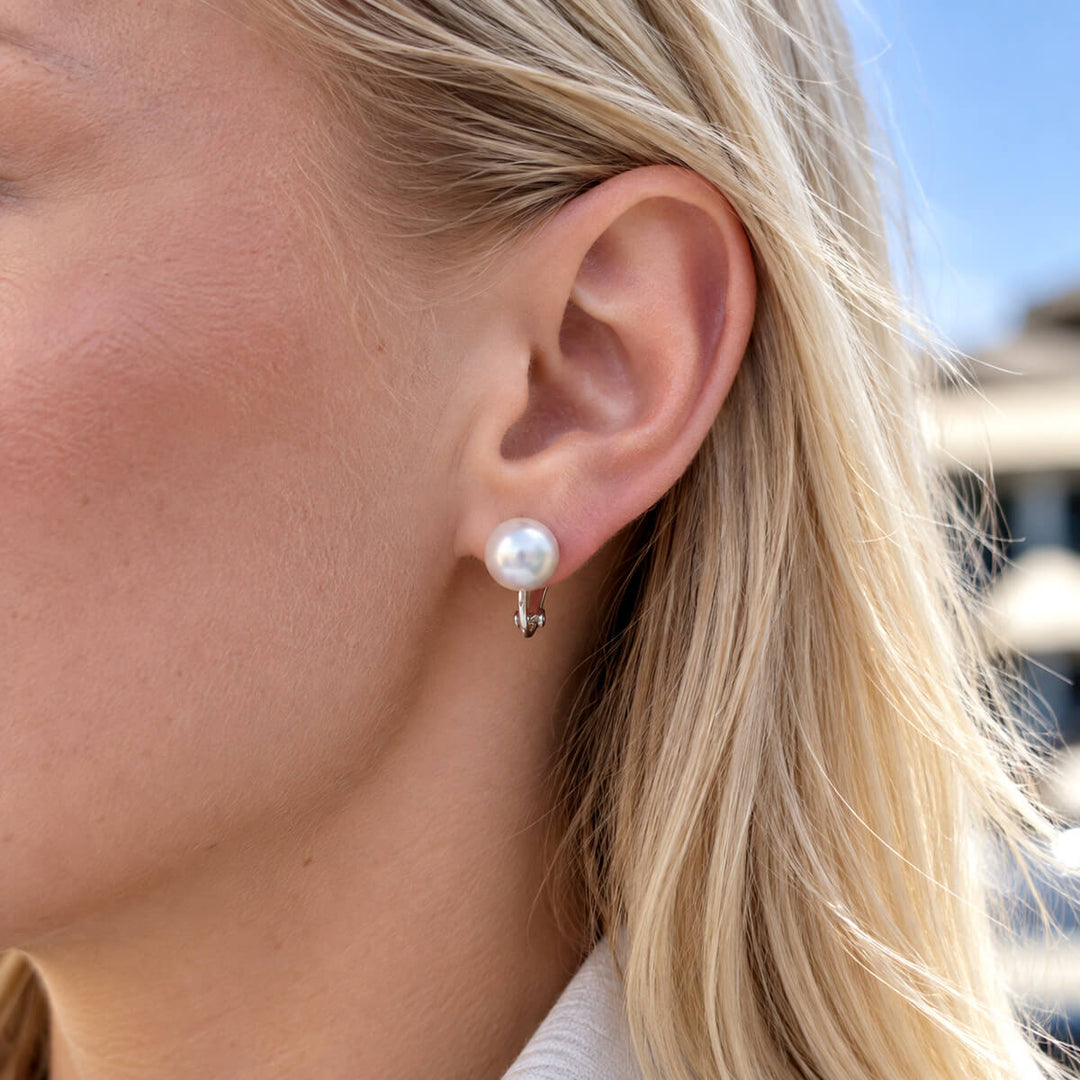 Valkoinen litteä 12 mm helmiklipsikorvakoru korvassa